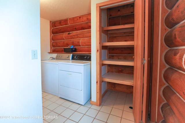 laundry area with rustic walls, light tile patterned floors, independent washer and dryer, and a textured ceiling