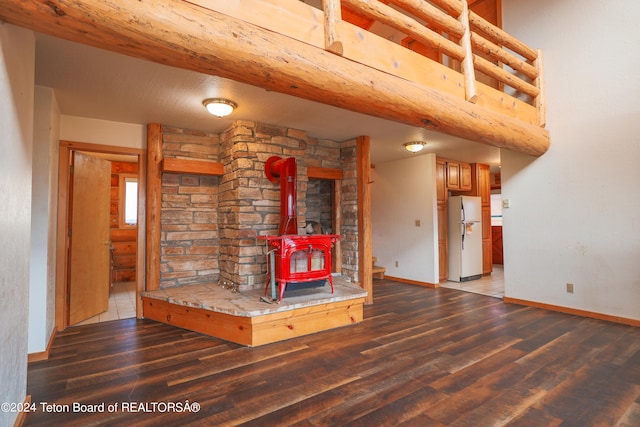 unfurnished living room with hardwood / wood-style flooring and a wood stove