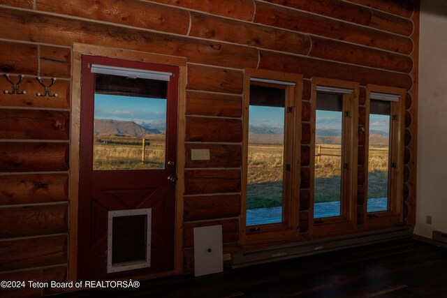 interior space with rustic walls, a mountain view, and wood finished floors