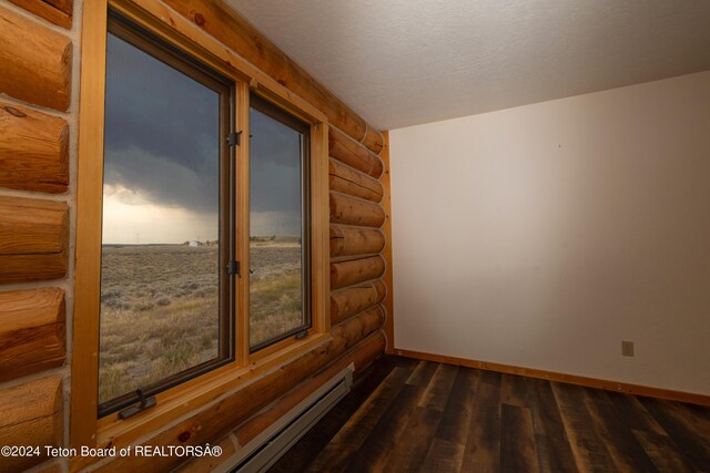 spare room featuring a textured ceiling and dark hardwood / wood-style flooring