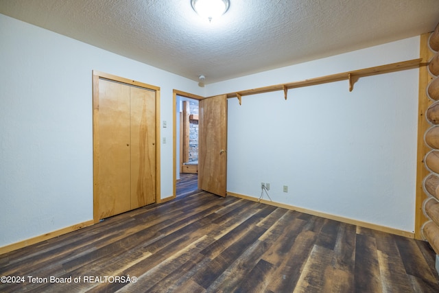 unfurnished room with a textured ceiling and dark hardwood / wood-style floors