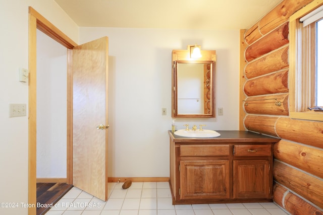 bathroom with log walls, baseboards, and vanity