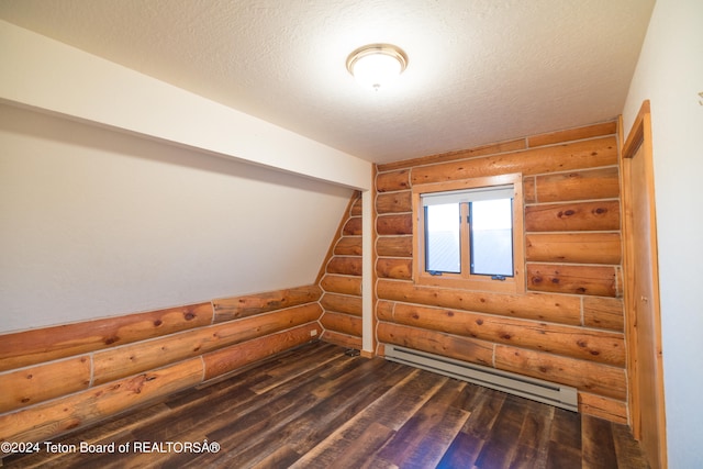 additional living space with a textured ceiling, a baseboard radiator, log walls, and dark hardwood / wood-style flooring