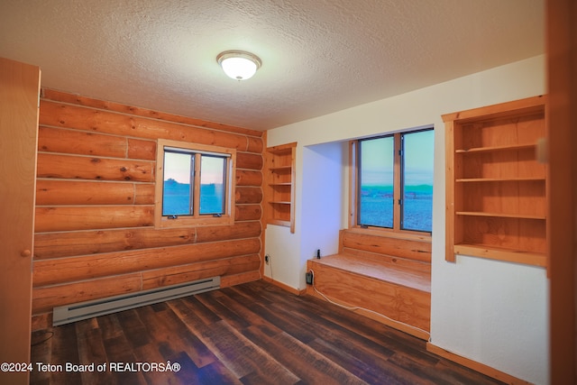 spare room with a wealth of natural light, a baseboard radiator, and dark hardwood / wood-style floors