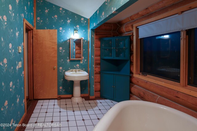 full bath featuring wallpapered walls, a freestanding tub, baseboards, and log walls