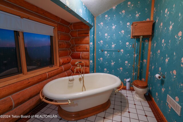 bathroom with rustic walls, toilet, a washtub, and tile patterned floors