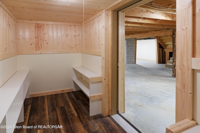 interior space featuring concrete flooring, wood ceiling, and wooden walls