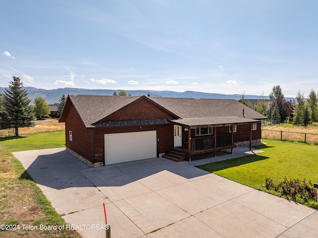 view of front of home with a front yard, a mountain view, and a garage