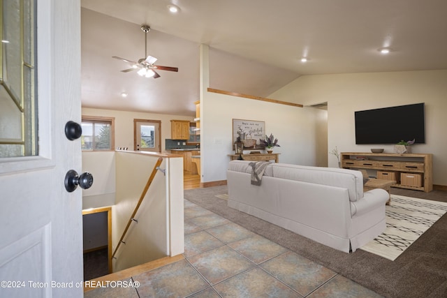 living room with ceiling fan, lofted ceiling, and tile patterned floors