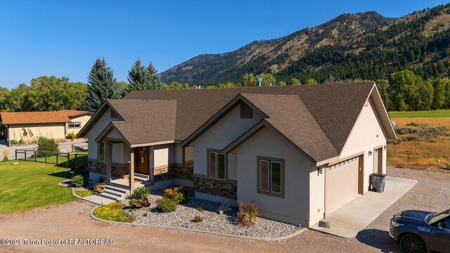 view of front of home with a mountain view, a garage, and a front lawn