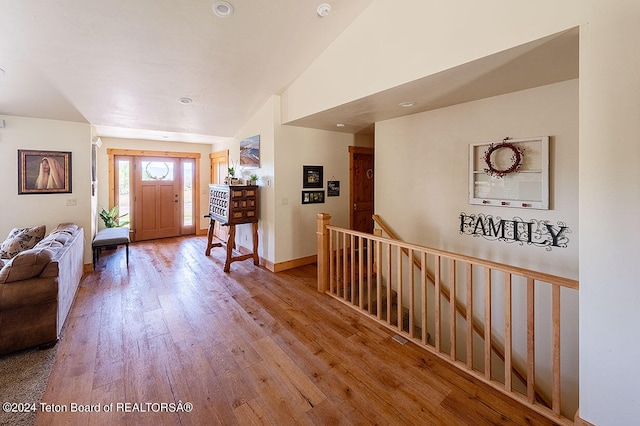 entryway with light wood-type flooring and vaulted ceiling