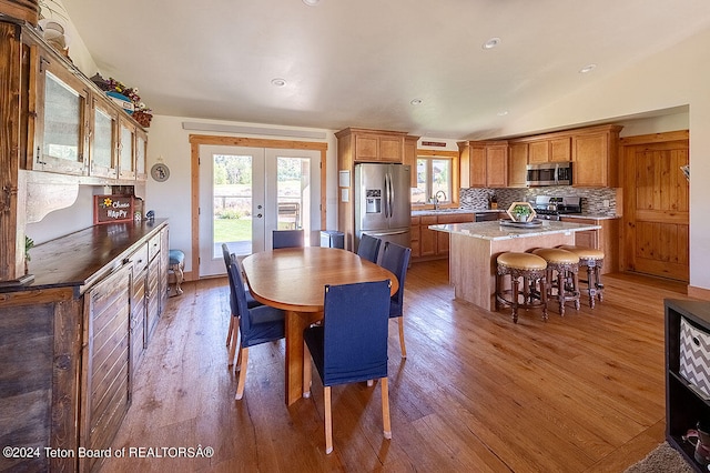 dining area featuring french doors, lofted ceiling, hardwood / wood-style floors, and sink