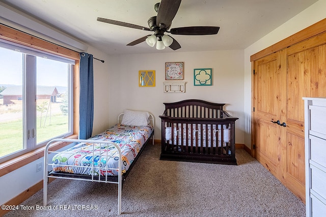 carpeted bedroom featuring a closet and ceiling fan