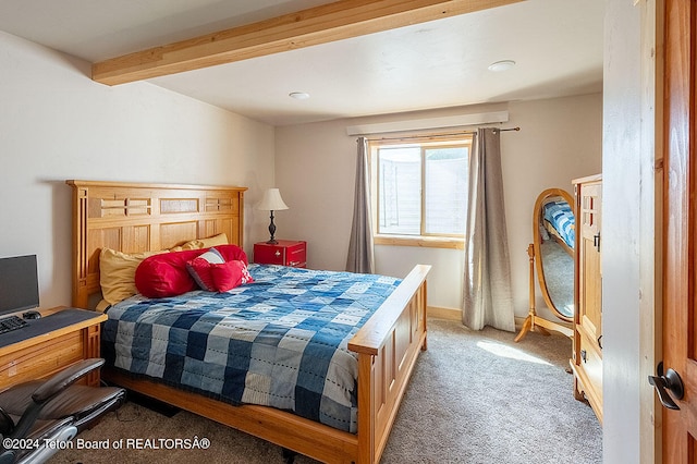 carpeted bedroom with beamed ceiling