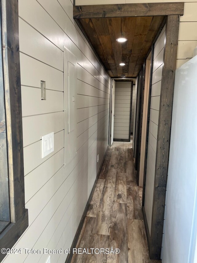 corridor featuring wooden ceiling, wooden walls, and dark hardwood / wood-style floors