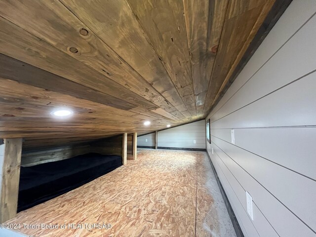 bonus room with lofted ceiling, wood walls, and wood ceiling