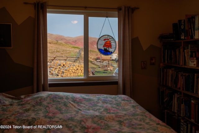 bedroom featuring multiple windows and a mountain view