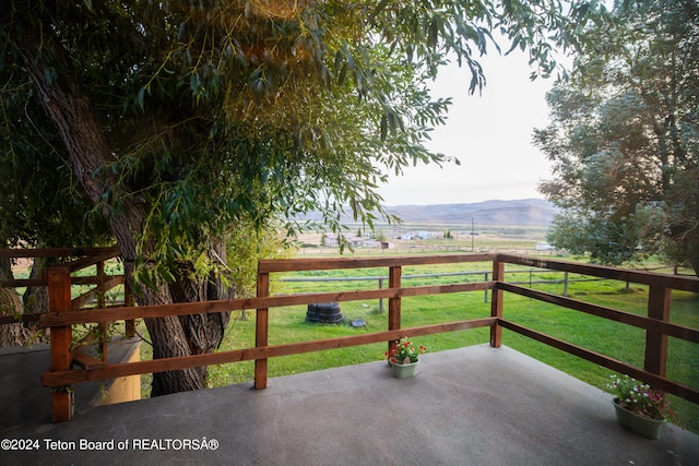 view of patio featuring a mountain view, central AC unit, and a rural view