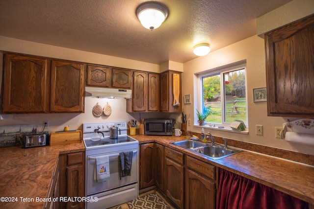 kitchen featuring stainless steel appliances, a textured ceiling, and sink