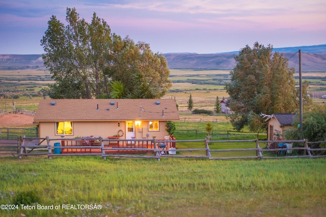 exterior space featuring an outbuilding, a deck with mountain view, and a rural view