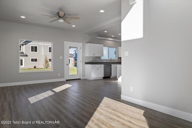 unfurnished living room with ceiling fan, dark wood-type flooring, and sink