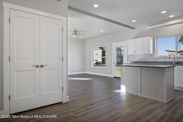 kitchen featuring dark stone counters, white cabinetry, dark hardwood / wood-style floors, and ceiling fan