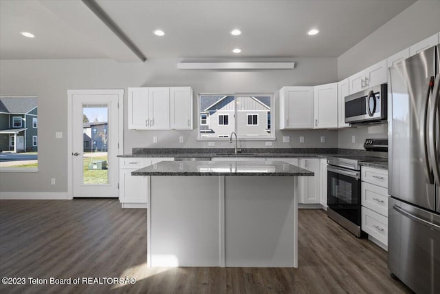 kitchen with white cabinetry, dark wood-type flooring, appliances with stainless steel finishes, and a kitchen island