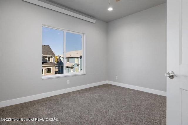 carpeted spare room with ceiling fan