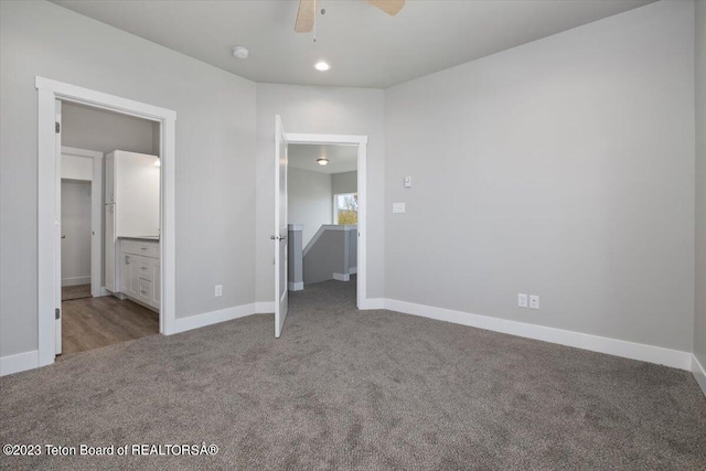 unfurnished bedroom with ceiling fan, ensuite bathroom, and carpet floors