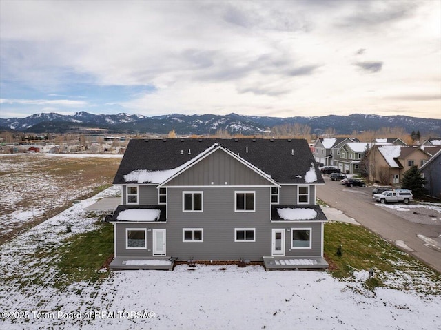 snow covered house featuring a mountain view