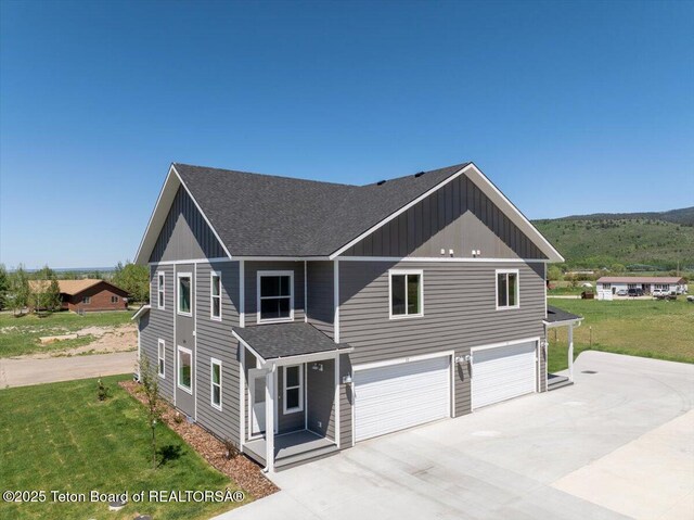 90 Alpine Trl Unit 31, Victor, ID 83455 - view of front of home featuring board and batten siding, driveway, an attached garage, roof with shingles, and a front yard
