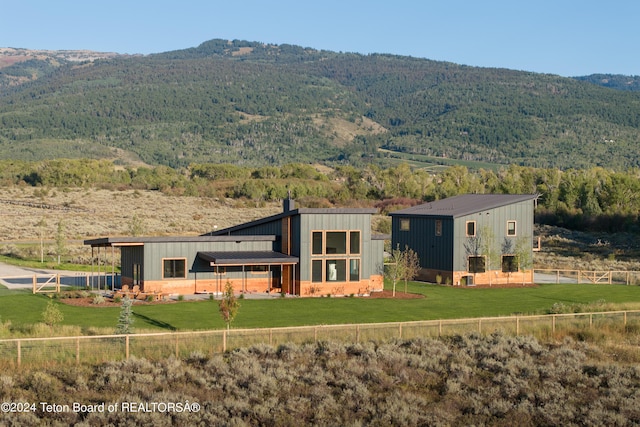 3176 Slinger Ct, Driggs, ID 83422 - back of house featuring a mountain view, a chimney, board and batten siding, and a forest view