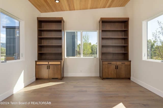 unfurnished living room featuring light hardwood / wood-style floors, wood ceiling, and vaulted ceiling