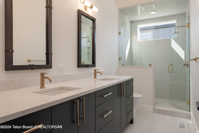 bathroom with vanity, toilet, and a shower with shower door