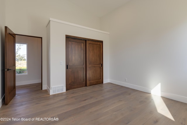 3176 Slinger Ct, Driggs, ID 83422 - unfurnished bedroom featuring baseboards, light wood finished floors, a closet, and a towering ceiling