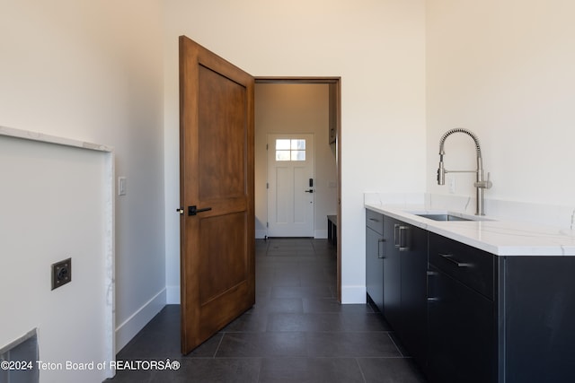 interior space featuring sink and dark tile patterned flooring