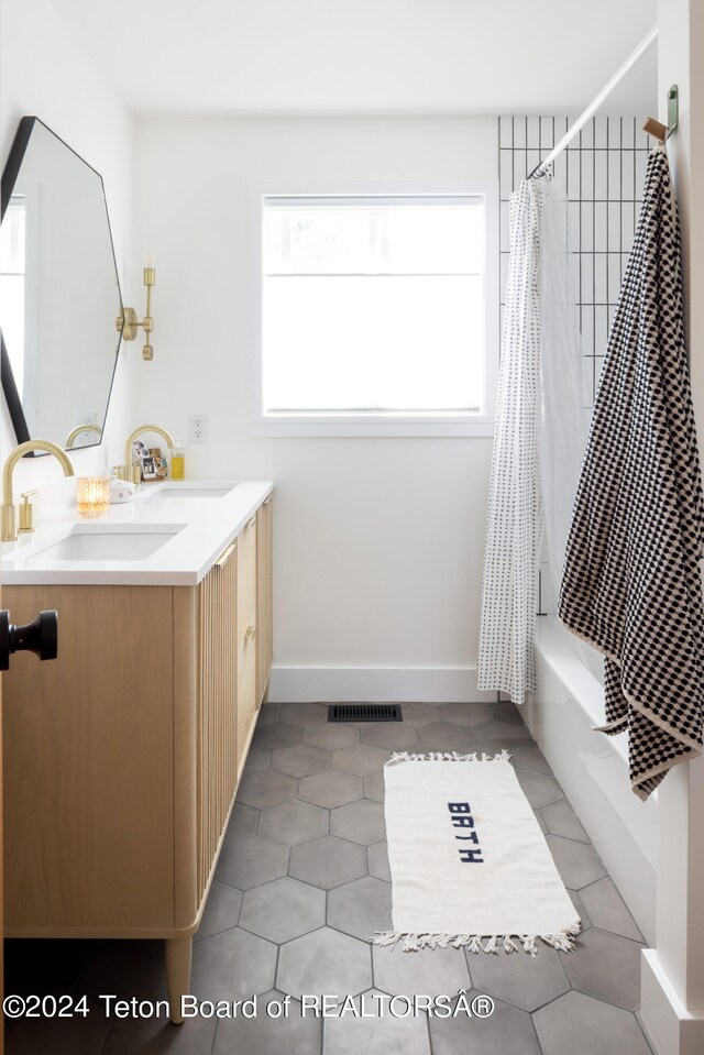 bathroom with vanity, shower / bathtub combination with curtain, and tile patterned flooring