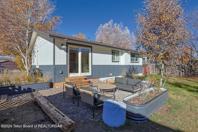 back of house featuring an outdoor hangout area, a patio, and a lawn