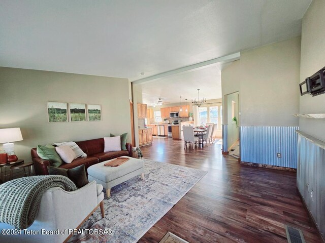 living room featuring a notable chandelier and dark wood-type flooring