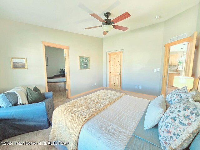 carpeted bedroom with ceiling fan and ensuite bathroom