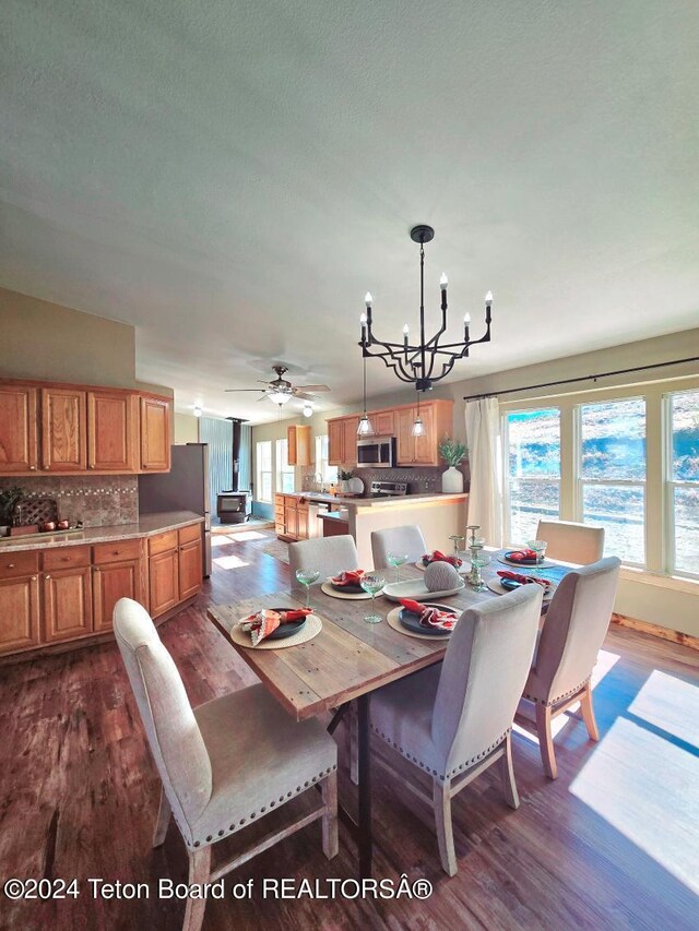 dining room featuring ceiling fan with notable chandelier and dark hardwood / wood-style flooring