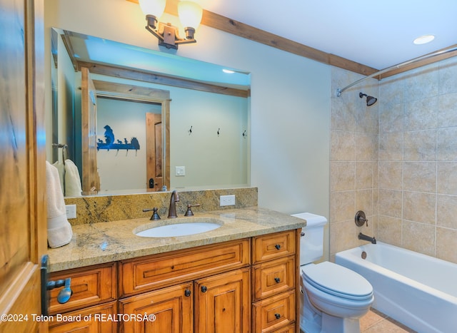 full bathroom featuring tile patterned floors, tiled shower / bath, vanity, and toilet