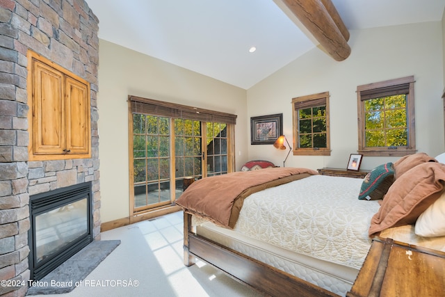 carpeted bedroom featuring a stone fireplace, lofted ceiling with beams, and access to exterior