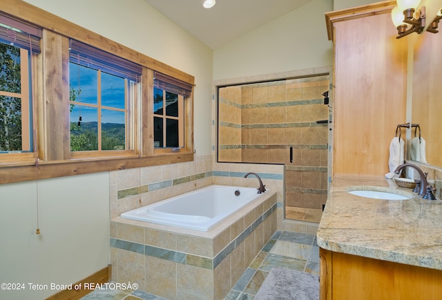 bathroom featuring plus walk in shower, vaulted ceiling, and vanity