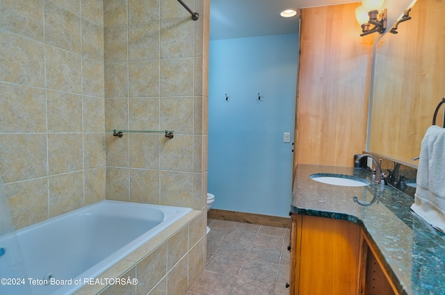 bathroom with vanity, tiled bath, tile patterned flooring, and toilet