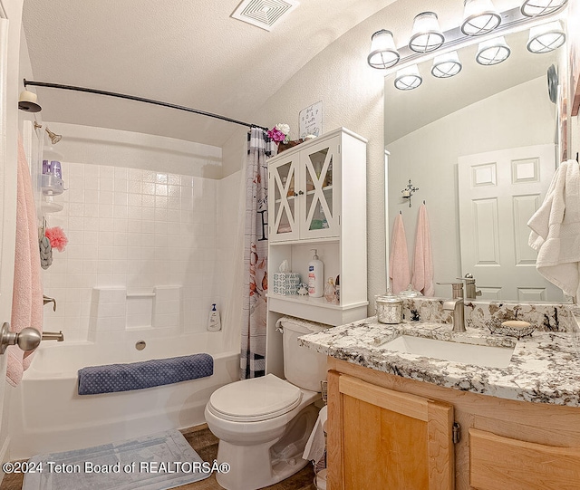 full bathroom featuring shower / bath combo, a textured ceiling, vaulted ceiling, toilet, and vanity