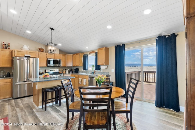 dining room with a chandelier, a wealth of natural light, light hardwood / wood-style floors, and lofted ceiling