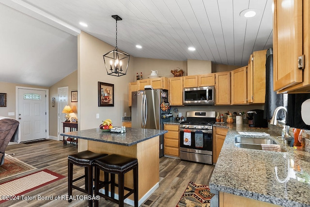 kitchen with sink, a kitchen island, lofted ceiling, and appliances with stainless steel finishes