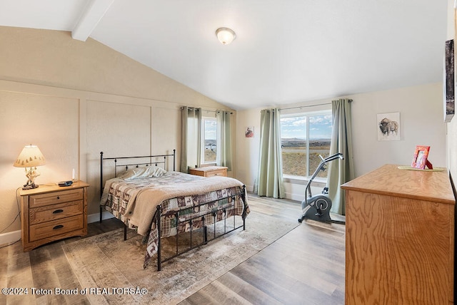 bedroom with hardwood / wood-style flooring and vaulted ceiling with beams