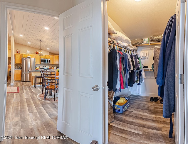 spacious closet featuring light hardwood / wood-style floors and vaulted ceiling